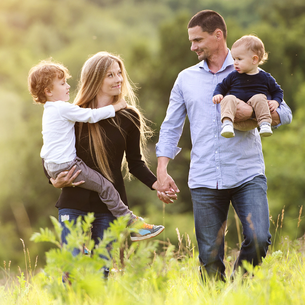 a family enjoying a walk through long grass