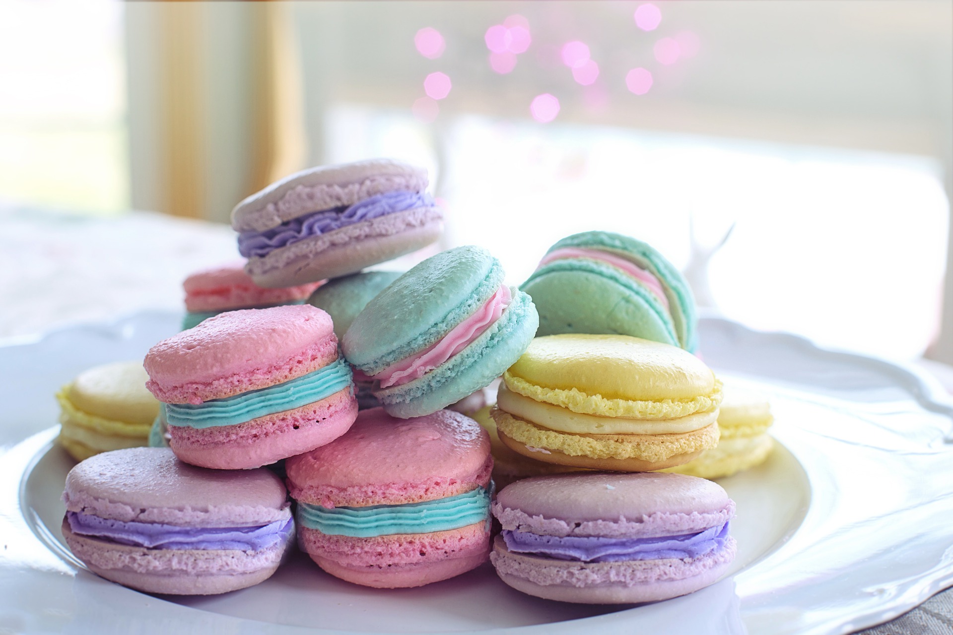 A stack of purple, green and yellow macaroonsm, with brightly coloured icing 