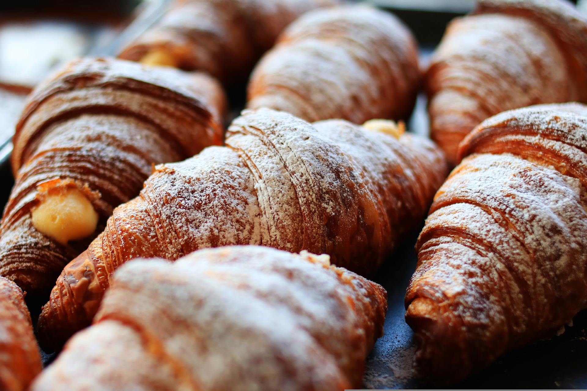 Close up picture of croissants, coated in sugar, fresh out of the oven.