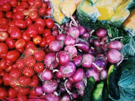 Bunches of small tomatoes, purple radishes and deep green cucumbers